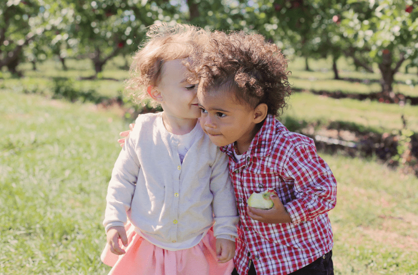 Toddlers hugging in an apple orchard - New Baby New Paltz