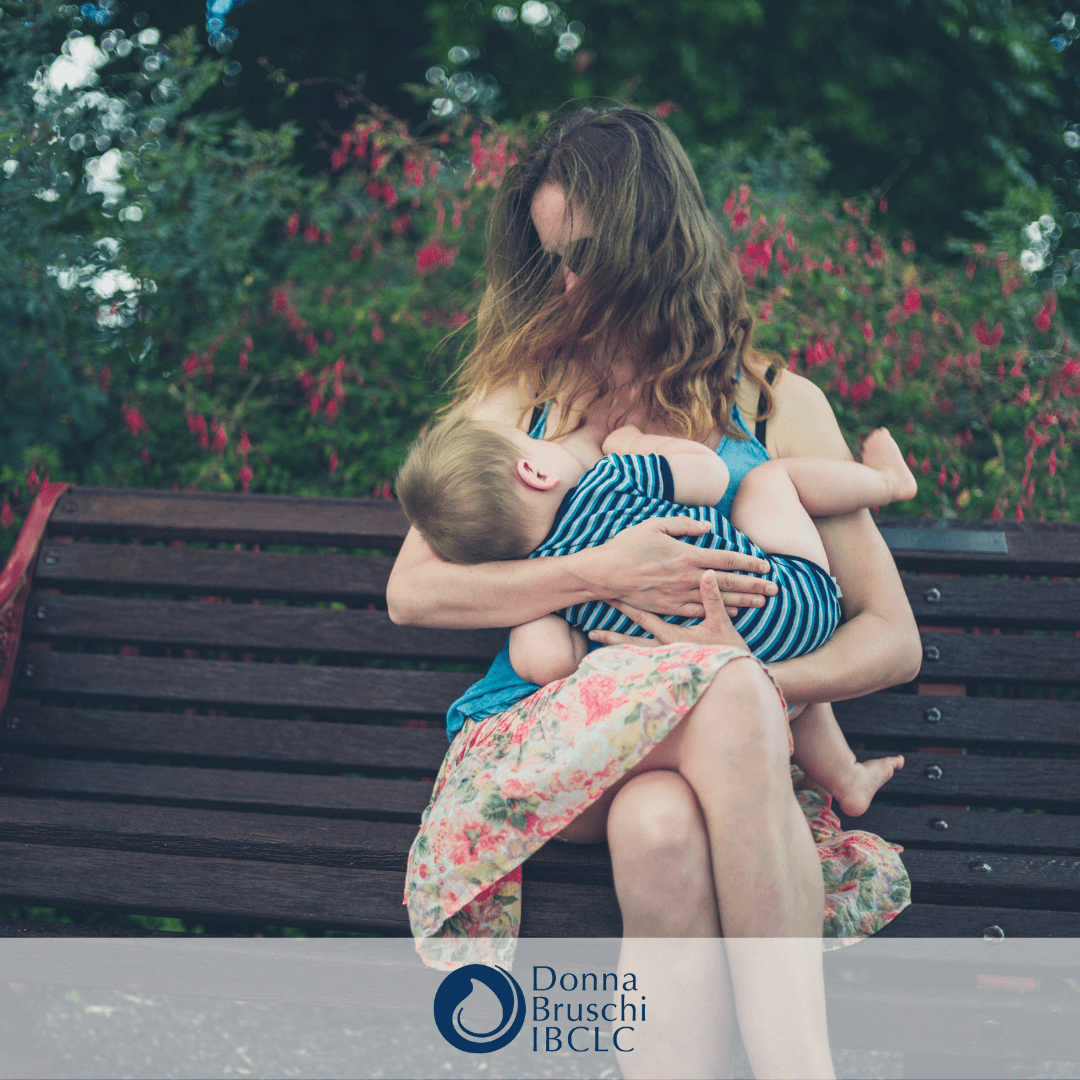 Mother sitting on a bench nursing her baby